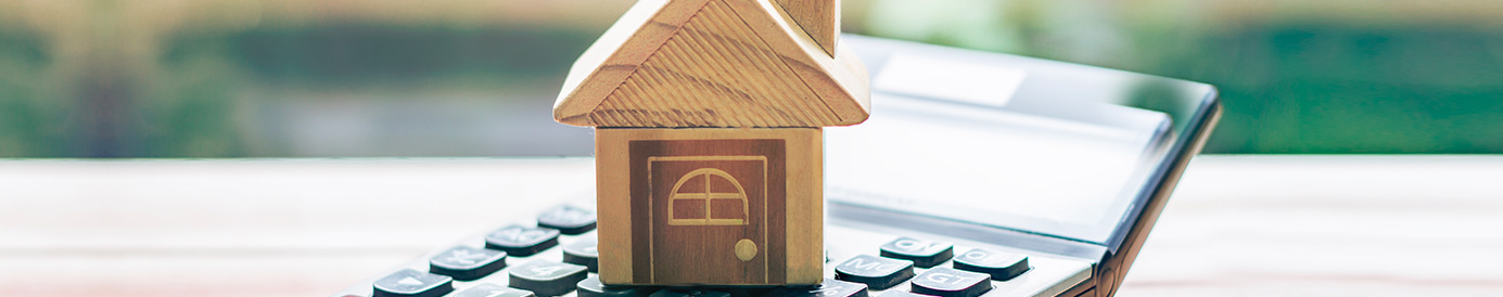 Tiny wooden house on top of a calculator